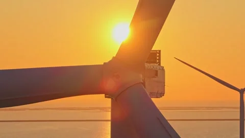 Offshore wind turbine rotating against beautiful golden sunset Vidéo 333648984