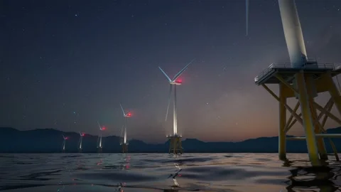 Offshore wind turbines spin around in the starry night marine background. Video stock 201132296
