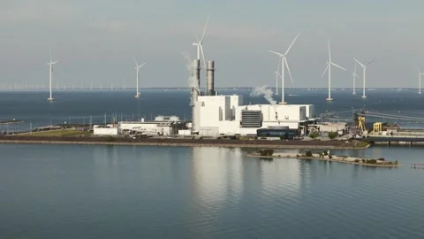 Offshore windfarm and gas fired power sation on Dutch shores Stock Footage 289964544