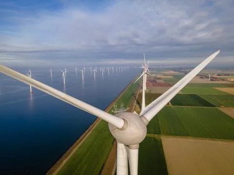 Offshore windmill park with clouds and a blue sky, windmill park in the ocean Stock Photos