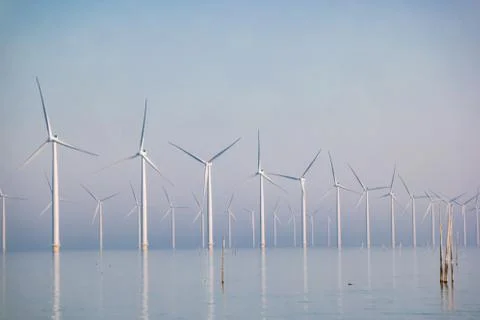 Offshore windmill park with clouds and a blue sky, windmill park in the ocean Stock Photos