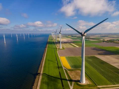 Offshore windmill park with clouds and a blue sky, windmill park in the ocean Stock Photos
