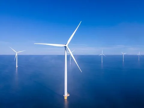 Offshore windmill park with clouds and a blue sky, windmill park in the ocean Stock Photos