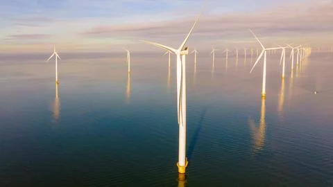 Offshore windmill park with clouds and a blue sky Stock Photos