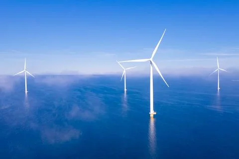Offshore windmill park with clouds and a blue sky Stock Photos