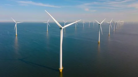 Offshore windmill park with clouds and a blue sky Stock Photos
