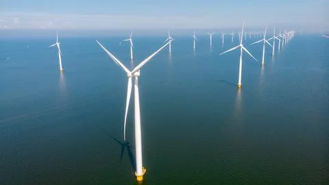 Offshore windmill park with clouds and a blue sky Stock Photos