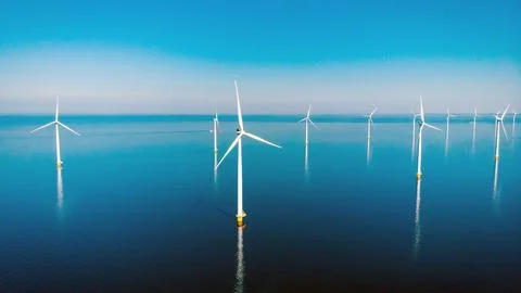 Offshore windmill park with clouds and a blue sky Stock Photos