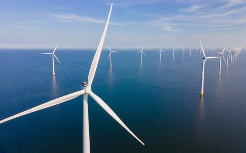 Offshore windmill park with clouds and a blue sky Stock Photos