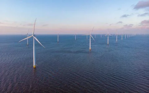 Offshore windmill park with clouds and a blue sky Stock Photos