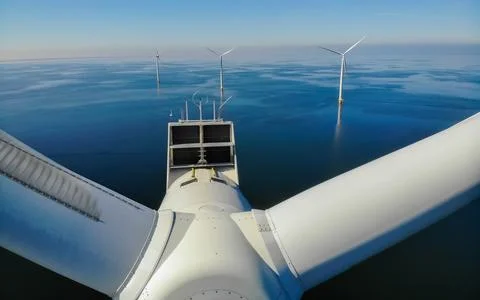 Offshore windmill park with clouds and a blue sky Stock Photos