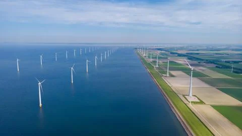 Offshore windmill park with clouds and a blue sky Stock Photos