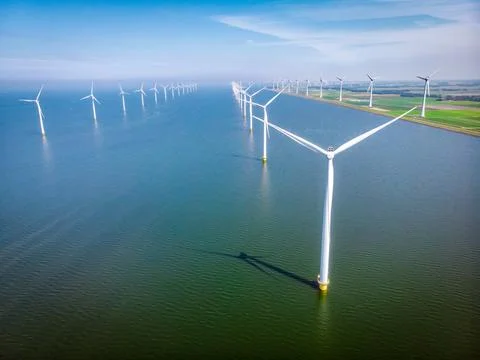 Offshore windmill park with clouds and a blue sky Stock Photos