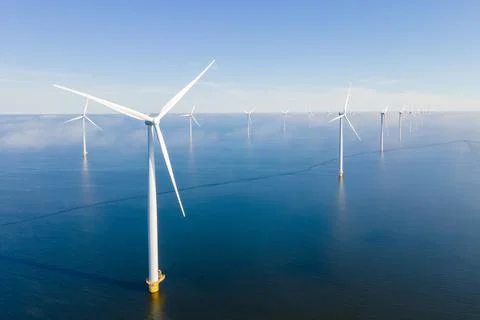 Offshore windmill park with clouds and a blue sky Stock Photos