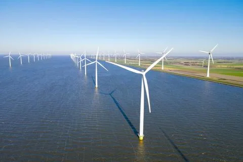 Offshore windmill park with clouds and a blue sky Stock Photos