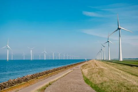 Offshore windmill park with stormy clouds and a blue sky, windmill park in the Stock Photos
