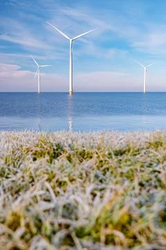 Offshore windmill park with stormy clouds and a blue sky, windmill park in the Stock Photos