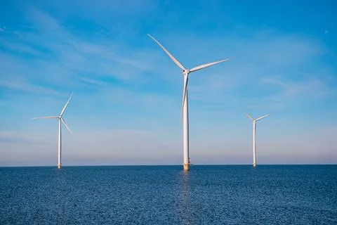 Offshore windmill park with stormy clouds and a blue sky, windmill park in the Stock Photos