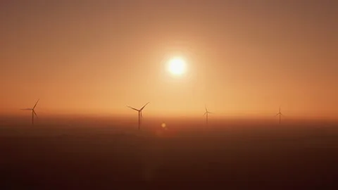 Offshore windmills rotate covered with heavy fog at sunset Stock Footage 166033900