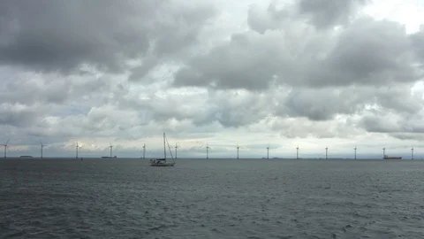 Offshore windmills sailboat passing Stock Footage 117237359