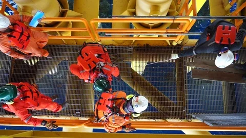 Offshore workers changing new galvanised grating at well head platform. Stock Footage 94557500