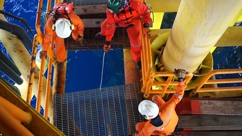 Offshore workers changing new galvanised grating at well head platform. Stock Footage 94558295