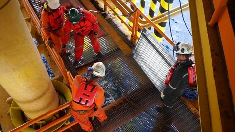 Offshore workers changing new galvanised grating at well head platform. Stock Footage 94558466