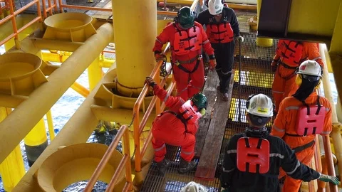 Offshore workers changing new galvanised grating at well head platform. Stock Footage 94558903