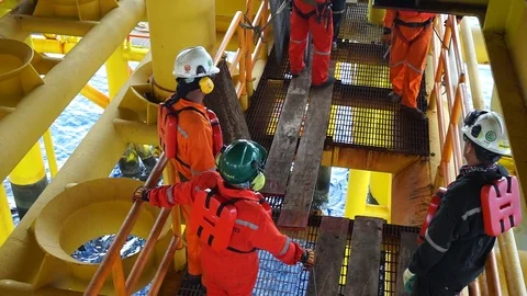 Offshore workers changing new galvanised grating at well head platform. Stock Footage 94559005