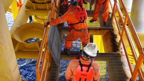Offshore workers changing new galvanised grating at well head platform. Stock Footage 94559370
