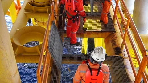 Offshore workers changing new galvanised grating at well head platform. Stock Footage 94559463