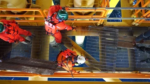 Offshore workers changing new galvanised grating at well head platform. Vídeos de archivo 94601240