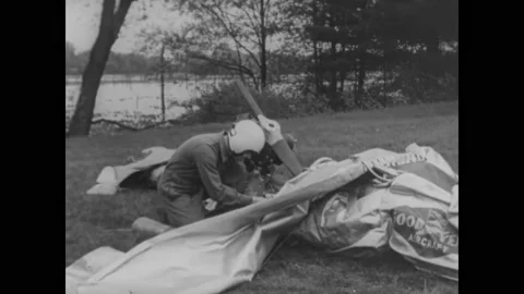 OHIO - 1958 - A US Navy pilot inflates a Goodyear inflatoplane on the banks of Video stock 313048228