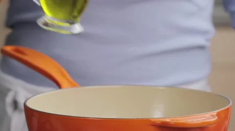 Oil being added to a saucepan Stock Footage 24656825
