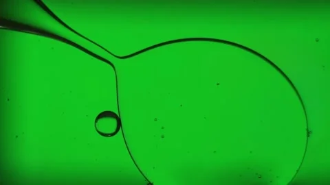 Oil bubbles, streaks on water in light green light, macroscopic Stock Footage 168129644
