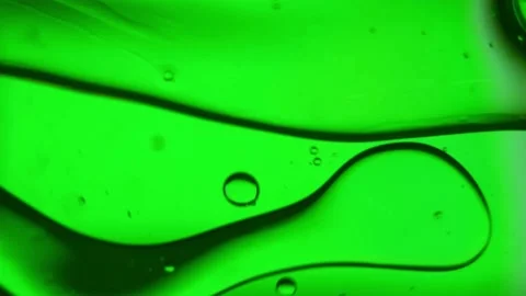 Oil bubbles, streaks on water in light green light, macroscopic Stock Footage 168129656
