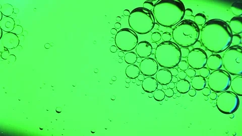 Oil bubbles on the water surface in motion, on a light green background, Stock Footage 149349510