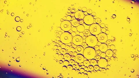 Oil bubbles on the water surface in motion, on a yellow background, Stock Footage 149349538