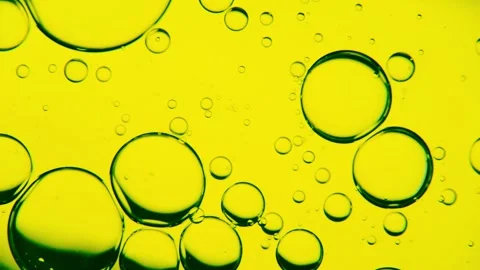 Oil bubbles on the water surface in motion, on a yellow-greenish background, Stock Footage 149349554