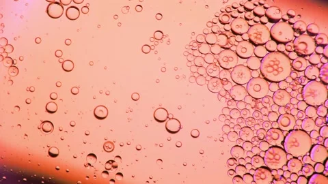 Oil bubbles on the water surface in motion, on a pink background, Stock Footage 149349574