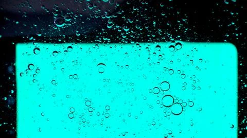 Oil bubbles on the water surface in motion, on a turquoise background, macro, Stock Photos
