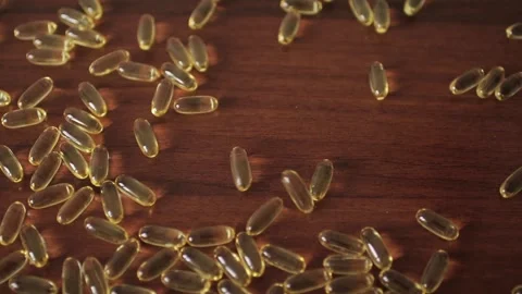 Oil capsules dropped on table. Stock Footage 101738977