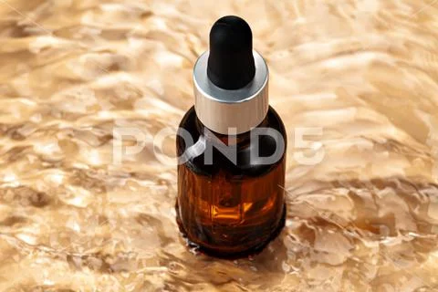 Oil cosmetic bottle on water waves background Stock Photos