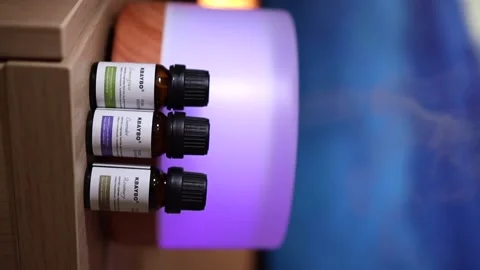 An Oil diffuser and bottle of sciential oils on a table Stock Footage 153515565