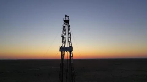 Oil drilling rig silhouette at sunset in desert oilfield. Stock Footage 334583978