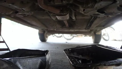 Oil drip under the car point of view checking at mechanic garage Stock Footage 153976445