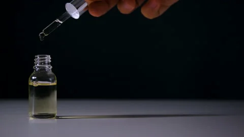 Oil drops falling from the pipette, on the black background. Video stock 154193383