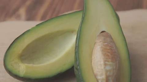 Oil drops over a half cut avocado on a table Stock Footage 68957136