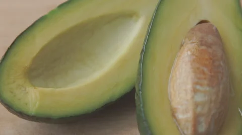 Oil drops over a half cut avocado on a table Stock Footage 68957165