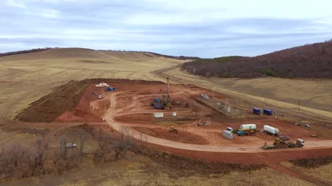 Oil field development. A drilling rig among the hills on a cloudy autumn day. Video stock 168121966